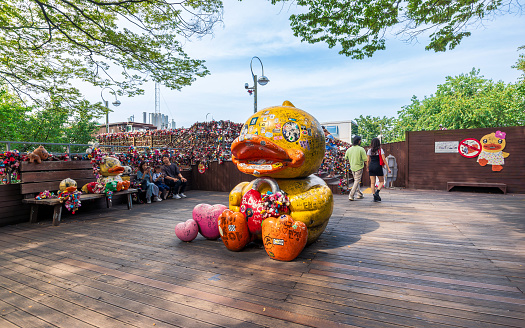 Seoul, South Korea, June 17, 2023: The yellow duck statue at N-Seoul Tower, surrounded by numerous love locks, is a highlight at this well-known tourist attraction.