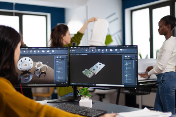 istock Industrial engineer woman working at pc with two monitors, screens showing CAD software 1857206133
