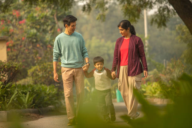 istock Happy parents and boy walking in park 1857208356