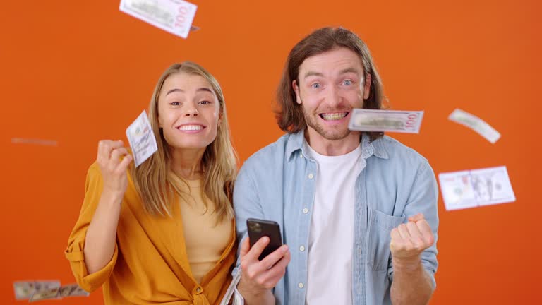 Man and woman win lottery while money pouring down from top