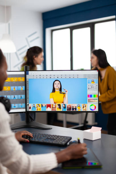 istock Black retoucher artist analysing images on pc with two monitors 1857219420