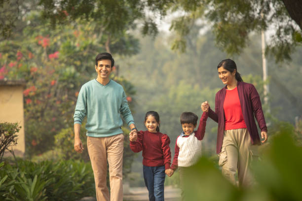 istock Happy parents and children walking in park 1857236209