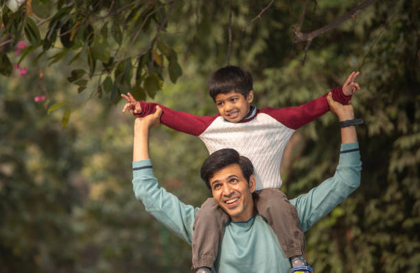 istock Happy son sitting on father shoulders in garden 1857245739