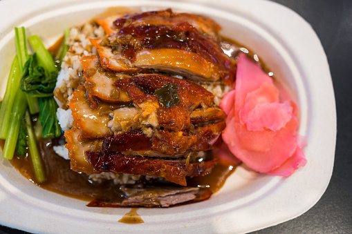 Roasted bbq duck with gravy sauce on top of rice. Top view