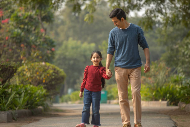 istock Father and daughter walking in garden 1857281944