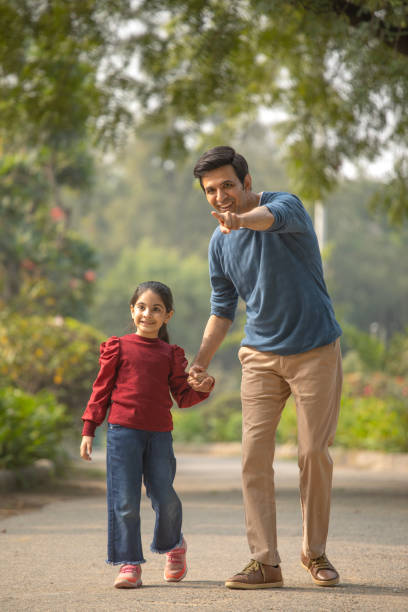istock Father and daughter walking in garden 1857282422