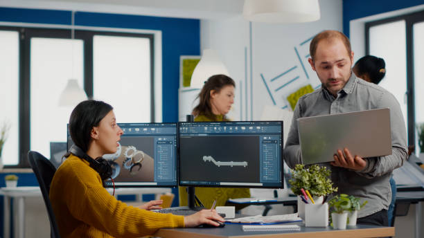 istock Man project supervisor holding laptop and talking with woman engineer 1857297475