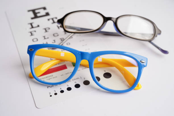 istock Glasses on eye exam chart to test eyesight accuracy of reading. 1857299028