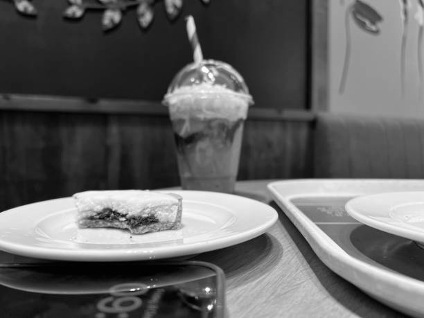 una torta mangiata a metà su un piatto con un frappè ghiacciato sullo sfondo - 6184 foto e immagini stock