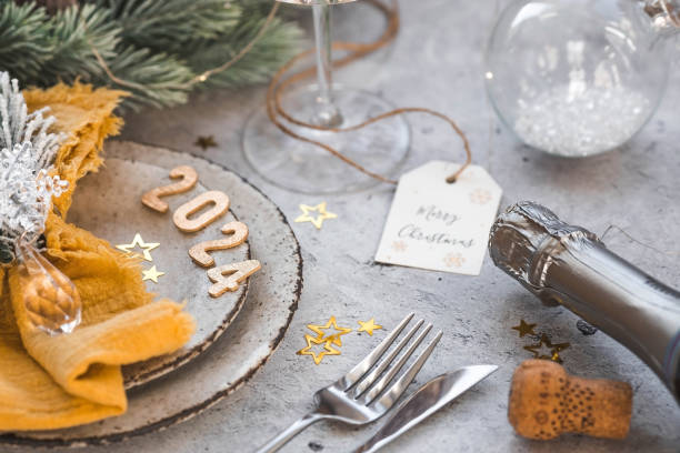 istock Table setting. Stylish plates, napkin, glass, champagne, Christmas tree branches and Christmas decorations on a gray background. The concept of merry Christmas and New Year 2024. 1857331293