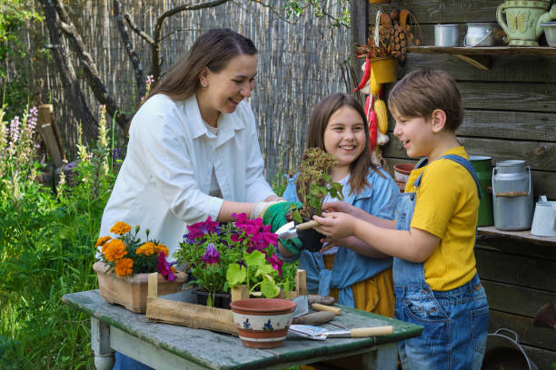 mano en la tierra, corazón en familia: una madre amorosa enseña a sus hijos la esencia de la jardinería, imbuyéndolos de habilidades para la vida y creando recuerdos duraderos. - mother superior fotografías e imágenes de stock