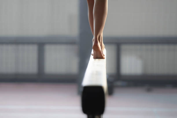 gimnasta mujer realizando en barra de equilibrio - miembro parte del cuerpo fotografías e imágenes de stock
