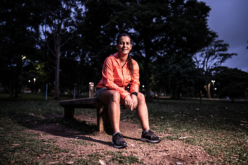 Portrait of a mature woman sitting on bench at the public park