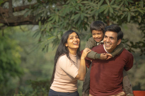istock Happy parents piggybacking son in park 1857385900