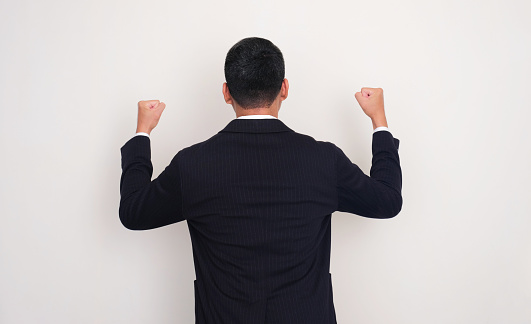 Back view of successful businessman clenched fist