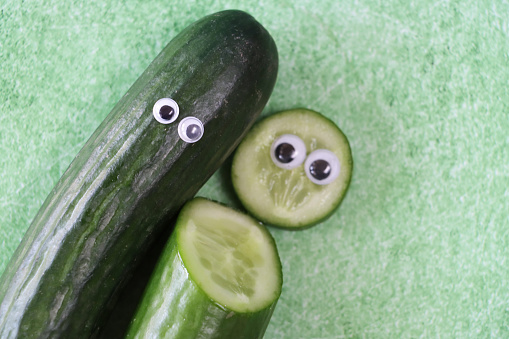 Stock photo showing a close-up view of a cucumber made into cartoon character with googly eyes for a touch of humour. Fun way to encourage healthy eating in children.