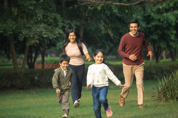 istock Parents running behind children in park 1857430495
