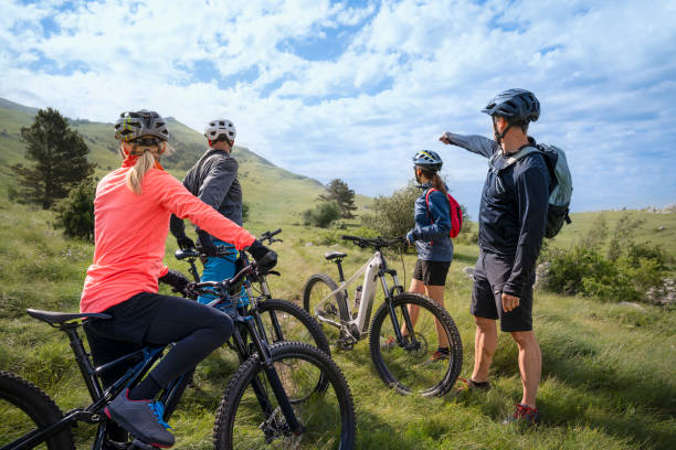 istock Male and female mountain biker talking in meadow 1857450588