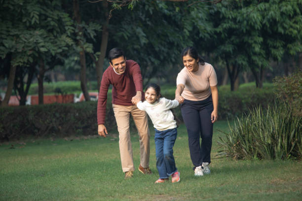 istock Playful girl pulling parents in garden 1857460116
