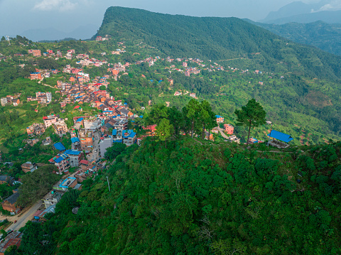 Backlit aerial view with godsrays and mist surrounding the Nepalese town of Bandipur. Main street with shops and commercial activities