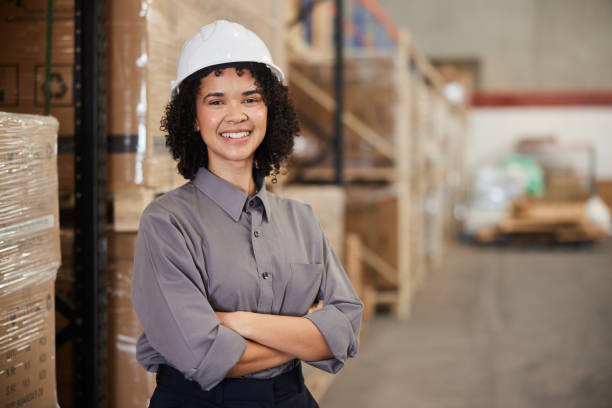 istock Smiling young female engineer standing by shelves in a shipping warehouse 1857480792