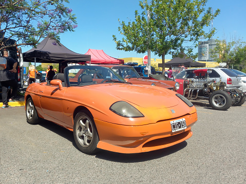 Buenos Aires, Argentina - Dec 10, 2023: Old orange Fiat Barchetta circa 1998 sporty stylish Italian roadster convertible at a classic car show in a parking lot. Sunny day