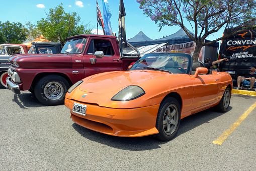 Buenos Aires, Argentina - Dec 10, 2023: Old orange Fiat Barchetta circa 1998 sporty stylish Italian roadster convertible at a classic car show in a parking lot. Sunny day