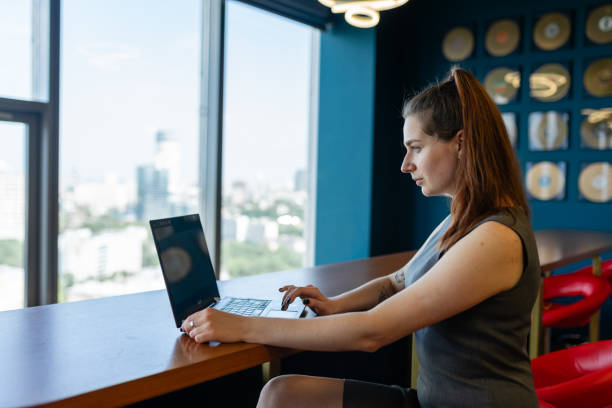 istock Focused business lady with ponytail works in lounge room 1857521480