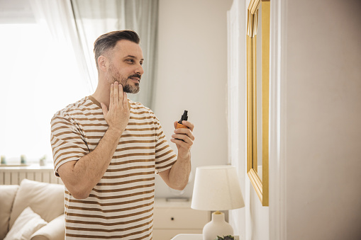 Man applying face cream after a morning shave.