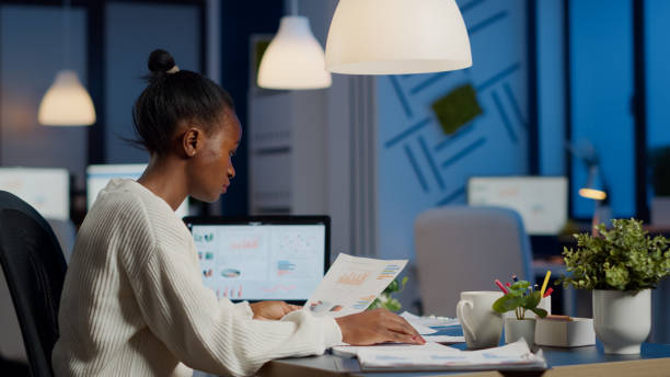 istock African business woman holding documents with graphics 1857541585