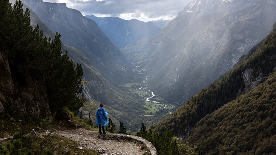 Hiker Enjoying Beautiful View on Alpine Valley from a Viewpoint With Raincoat on in Autumn Unstable Weather