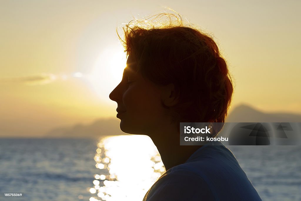Hermosa chica está en la puesta de sol de fondo - Foto de stock de Acantilado libre de derechos