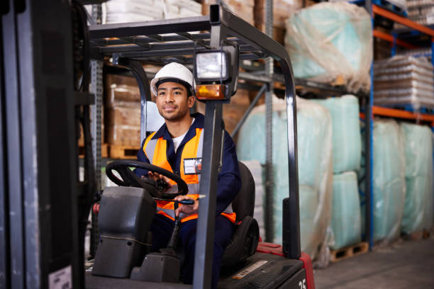 istock Smiling forklift operator driving on the floor in a shipping warehouse 1857552717