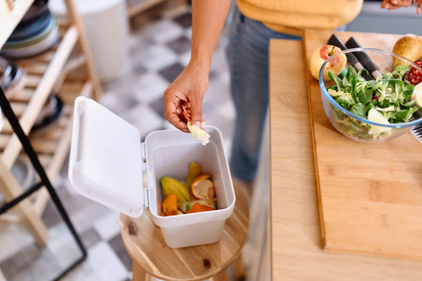 istock Woman separating her organic waste in the special bin 1857552734