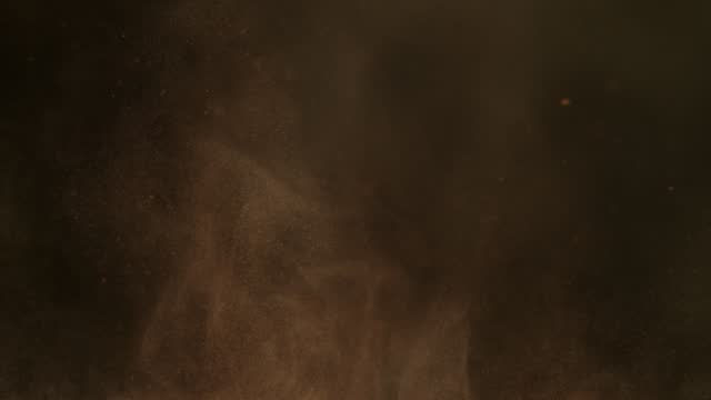 Super Slow Motion Shot of Brown Powder Particle Background Isolated on Black Background at 1000fps.