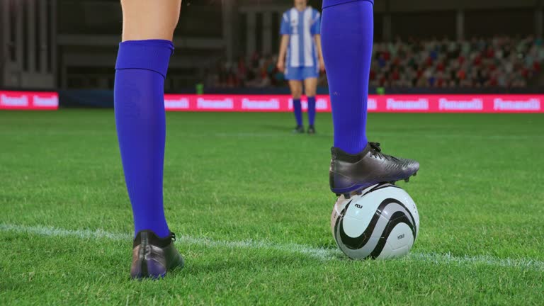 Female soccer player doing the kick off and passing the ball to a team mate