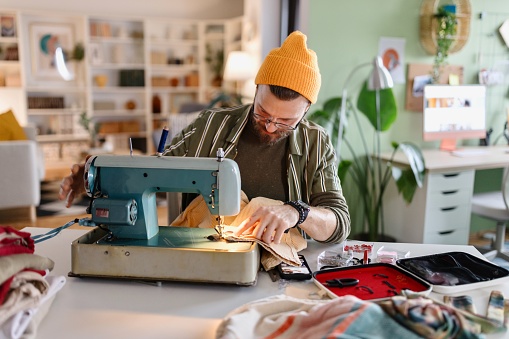 Man making and repairing clothes at home