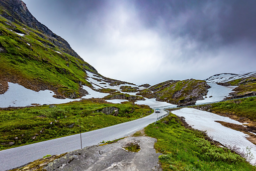 Magical places in Norway. The road to Lake Djupvatnet. The mountains are covered with freshly fallen snow. Summer trip to Norway. The road to the palace of the Snow Queen.