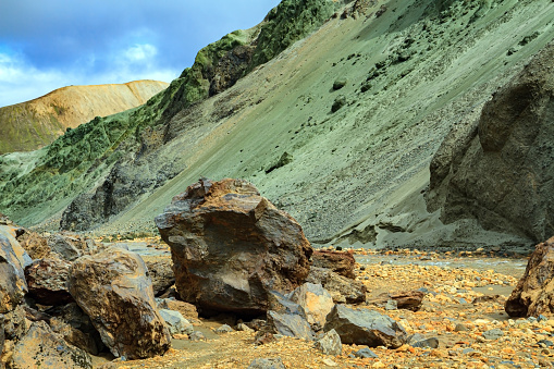 Travel to exotic Iceland. Huge stones covered with green moss. Colored mountains and thermal springs of Landmannalaugar.