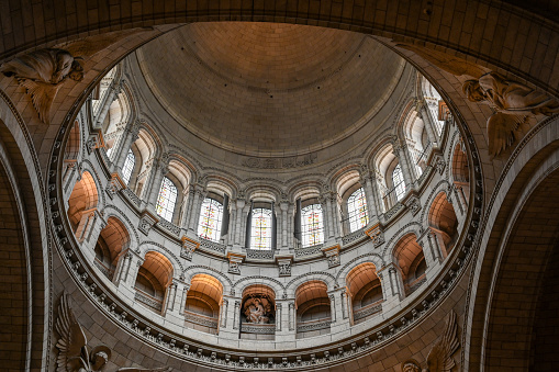 Paris, France,  July 1 2022. Fascinating photo of the interior of the dome of the Sacre Coeur Basilica. The scene is illuminated by the natural light that filters through the windows.