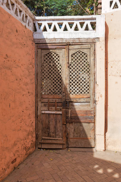 istock Vintage rustic weathered Doorway with Intricate Latticework on vibrant orange wall 1857691332