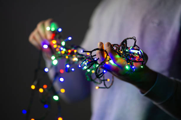 istock male hands holding tangled christmas decorative string lights, man untangling colorful christmas string lights 1857696139