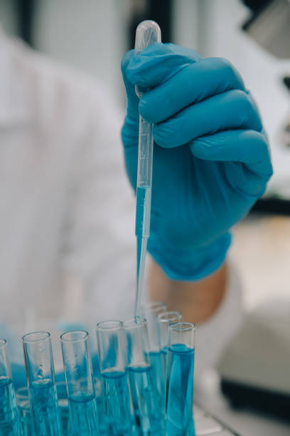 istock Scientist or medical in lab coat working in biotechnological laboratory, Microscope equipment for research with mixing reagents in glass flask in clinical laboratory. 1857727836