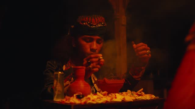 a shaman is performing a ritual with spells and offerings on a table