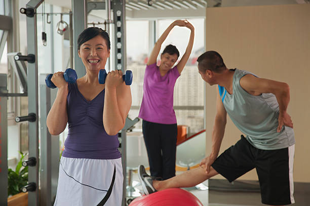 istock Mature woman lifting weights in the foreground 185775896