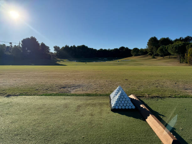 pyramide de balles de golf dans le practice avec un beau parcours de golf en arrière-plan - golf golf course swinging isolated photos et images de collection