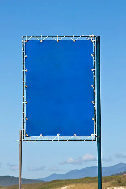 Blue beach sign for renting or selling beach products.