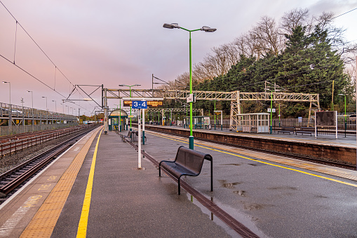 Railroad Station, Tring, Hertfordshire, England - November 3nd 2023:  The empty platform in the autumn sunset after a heavy rain. Tring is a kind of suburb to London and many commuters use the station.