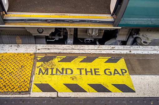 Euston Station, London, England - November 3nd 2023:  Sign painted on the floor to warn against the gab between the platform and the train - the warning is an integrated part of travelling in London