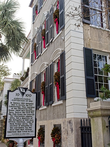 Charleston, South Carolina - USA, November 30, 2023. Poyas-Mordecai House decorated for Christmas with wreaths and red bows in each window. Historical Charleston home in elegant Adamesque style of architecture. Southern charm architecture along Meeting street in Charleston.